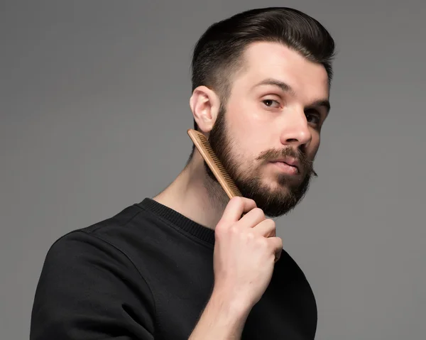Young man comb his beard and moustache — Stock Photo, Image
