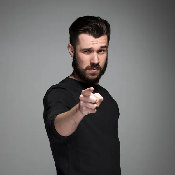 Young man with beard and mustaches, finger pointing towards the camera — Stock Photo, Image