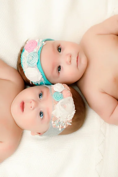 Two twin babies, girls in nice headbands — Stock Photo, Image