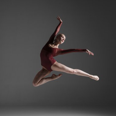 genç güzel modern stil dansçı bir stüdyo arka plan üzerinde atlama
