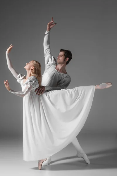 Dos jóvenes bailarines de ballet practicando. atractivas bailarinas en blanco —  Fotos de Stock