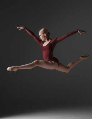 genç güzel modern stil dansçı bir stüdyo arka plan üzerinde atlama