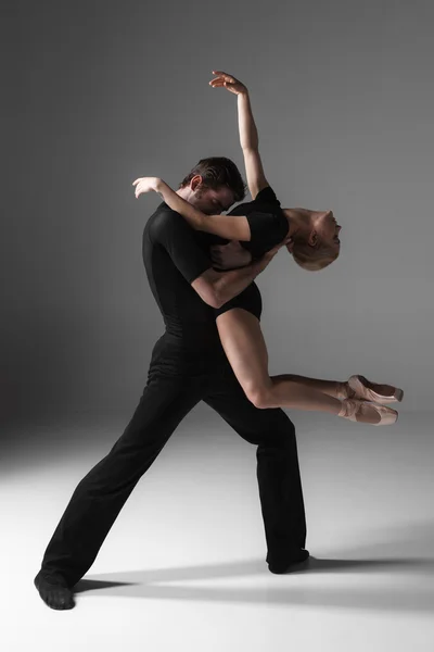 Deux jeunes danseurs de ballet modernes sur fond de studio gris — Photo