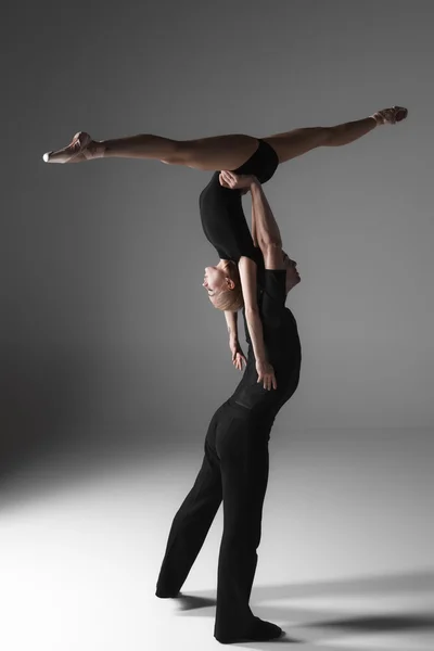 Deux jeunes danseurs de ballet modernes sur fond de studio gris — Photo