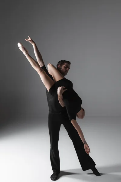 Дві молоді сучасні танцюристи балету на сірому фоні студії — стокове фото