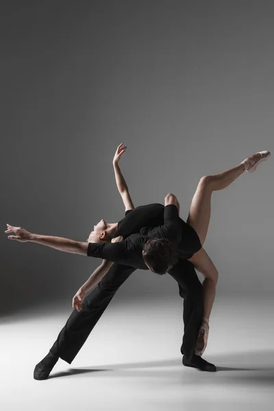 Zwei junge moderne Balletttänzerinnen auf grauem Studiohintergrund — Stockfoto