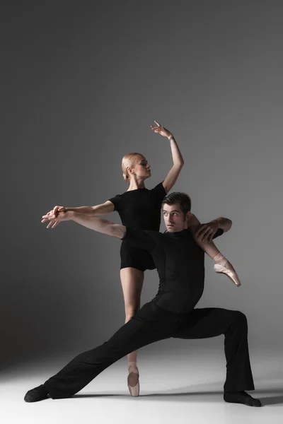 Dois jovens bailarinos modernos em fundo estúdio cinza — Fotografia de Stock