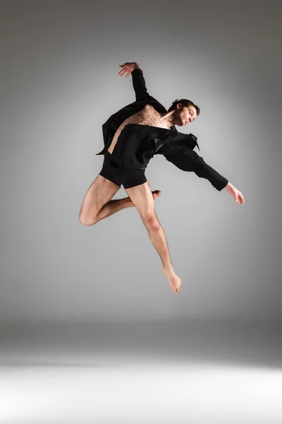 Молодой привлекательный современный балетный танцор прыгает на белом фоне — стоковое фото