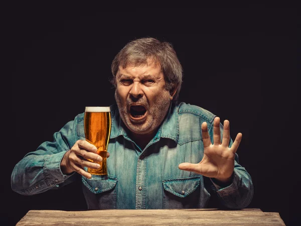 Зачарованный и эмоциональный вентилятор со стаканом пива — стоковое фото