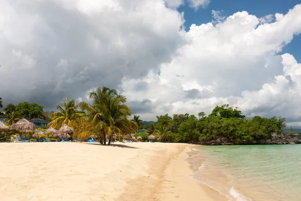 Beach on tropical island. Clear blue water, sand, clouds. — Stock Photo, Image