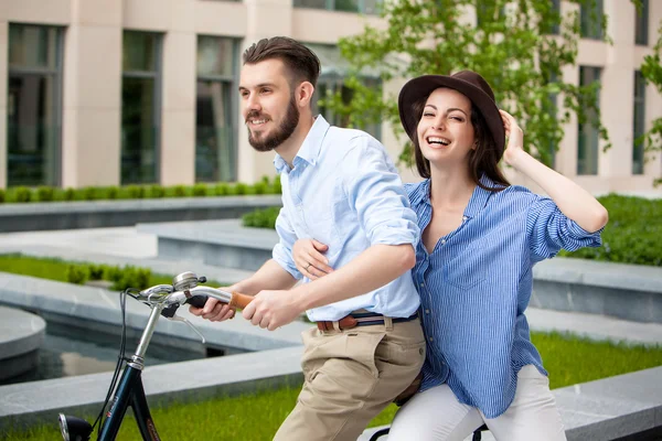 Pareja joven sentada en una bicicleta — Foto de Stock