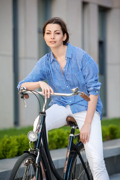 Mooi meisje, zittend op een fiets op straat — Stockfoto