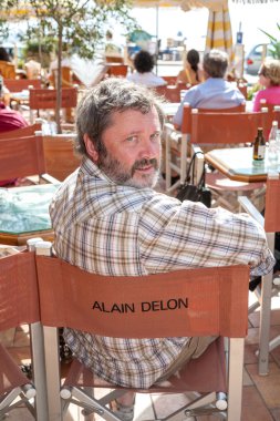 ccannes, Fransa - Eylül 17, 2008: Cannes sokak kafe. yazıt alain delon ile sandalye üzerinde oturan adam