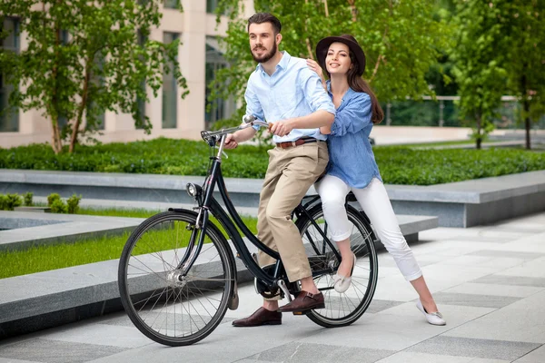 Pareja joven sentada en una bicicleta — Foto de Stock