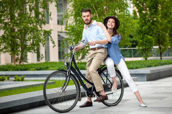 Pareja joven sentada en una bicicleta — Foto de Stock