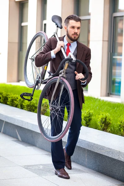 Beau homme d'affaires portant son vélo — Photo