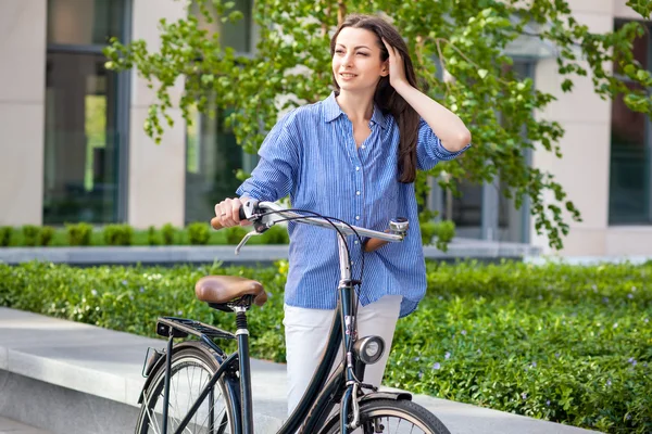 Piękna dziewczyna z rowerem na drodze — Zdjęcie stockowe