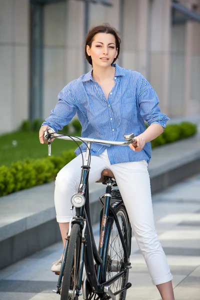 Ładna dziewczyna siedzi na rower na ulicy — Zdjęcie stockowe
