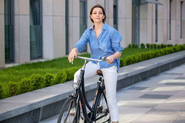 Mooi meisje, zittend op een fiets op straat — Stockfoto