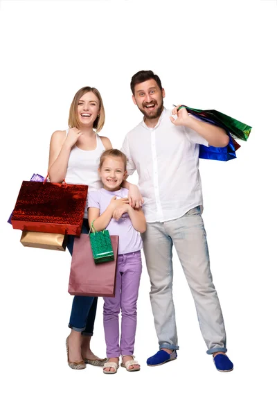 Happy family with shopping bags standing at studio — Stock Photo, Image