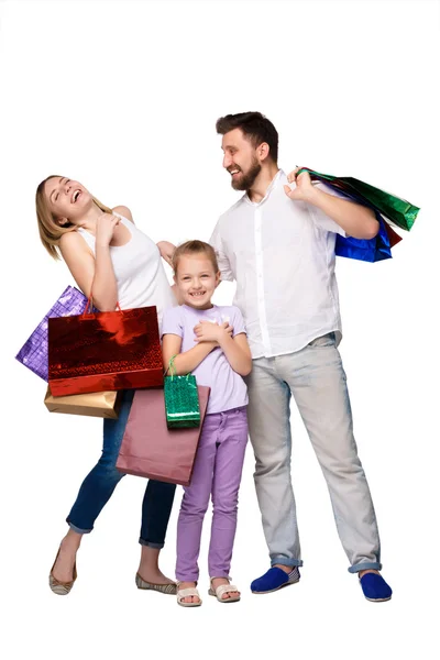 Família feliz com sacos de compras em pé no estúdio — Fotografia de Stock