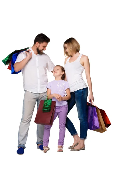 Familia feliz con bolsas de compras de pie en el estudio — Foto de Stock