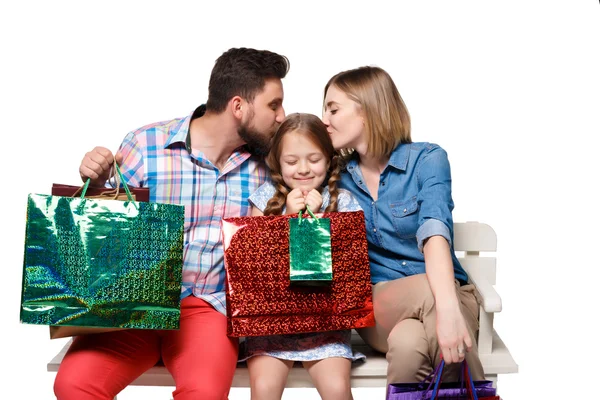 Família feliz com sacos de compras sentados no estúdio — Fotografia de Stock