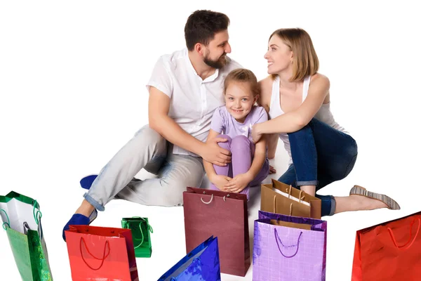 Счастливая семья с сумками для покупок сидит в студии — стоковое фото