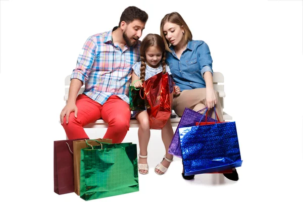 Happy family with shopping bags sitting at studio — Stok fotoğraf