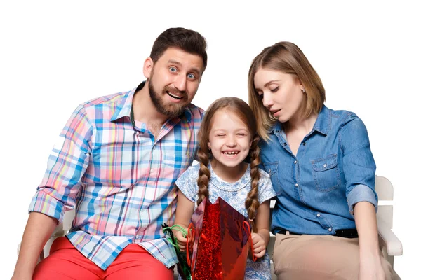 Happy family with shopping bags sitting at studio — Stock Photo, Image