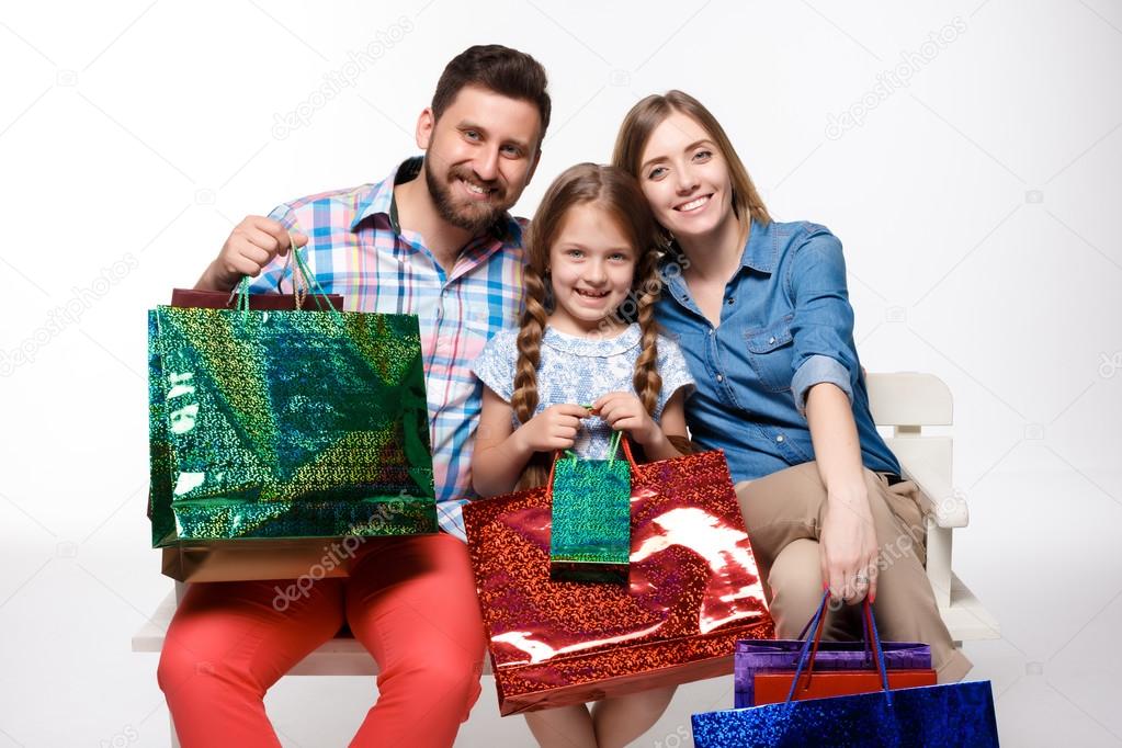 Happy family with shopping bags sitting at studio 