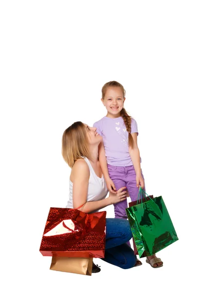 Счастливы мать и дочь с сумками для покупок, стоящими в студии — стоковое фото