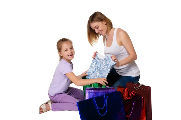 Счастливые мать и дочь с сумками для покупок сидят в студии — стоковое фото