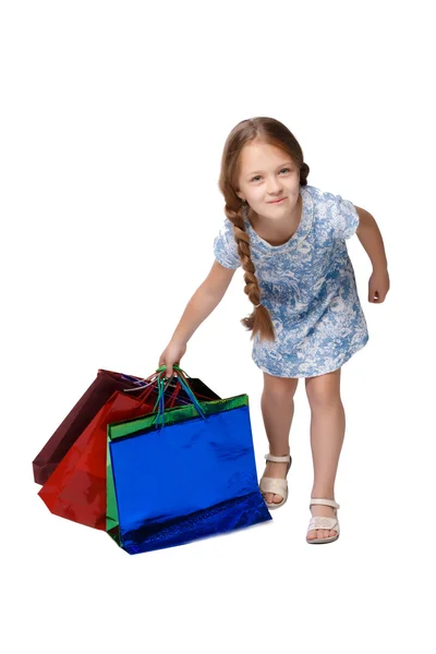 Happy girl with shopping bags standing at studio — Stockfoto