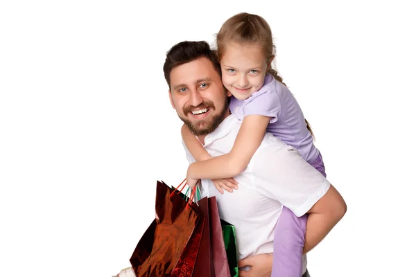 Happy father and daughter with shopping bags standing at studio — Stock Photo, Image
