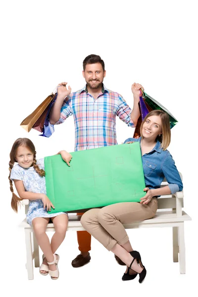 Happy family with shopping bags sitting at studio — Stockfoto