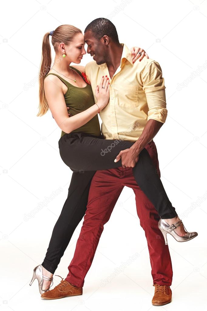 Young couple dances Caribbean Salsa, studio shot