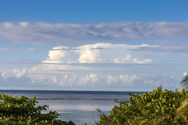 ชายหาดบนเกาะเขตร้อน น้ําสีฟ้าใสและท้องฟ้า — ภาพถ่ายสต็อก