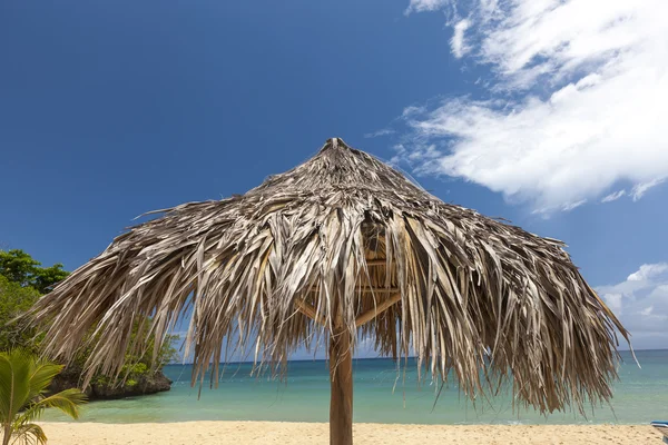 Straw umbrella on a tropical beach — Stock Photo, Image