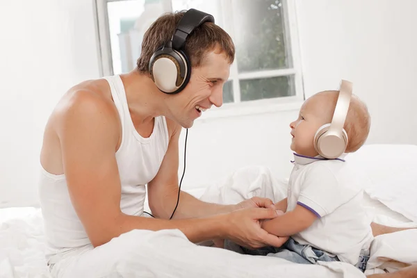 Young father with his nine months old som on the bed at home — Stock Photo, Image