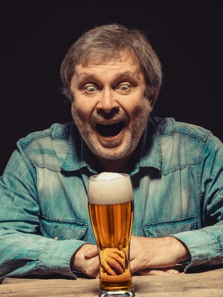 Кричущий чоловік у джинсовій сорочці зі склянкою пива — стокове фото
