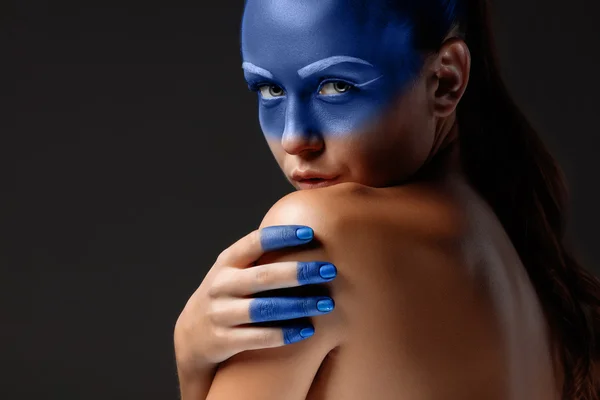 Retrato de uma mulher que está posando coberta de tinta azul — Fotografia de Stock