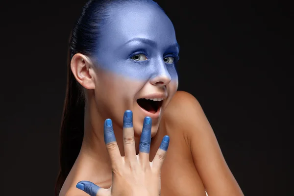 Портрет женщины, которая позирует покрытой синей краской — стоковое фото