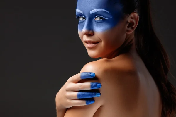 Retrato de uma mulher que está posando coberta de tinta azul — Fotografia de Stock