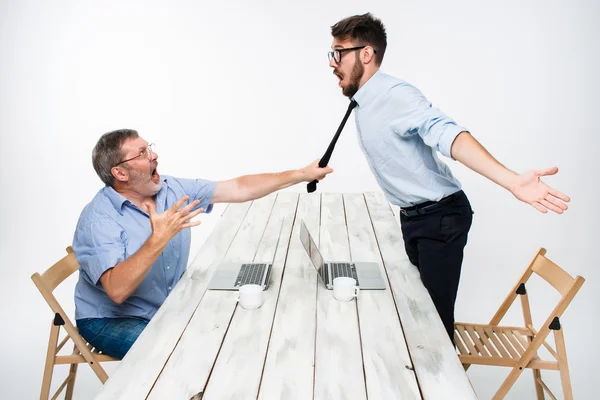 Деловой конфликт. Двое мужчин выражают негатив, в то время как один человек хватает галстук ее оппонента — стоковое фото