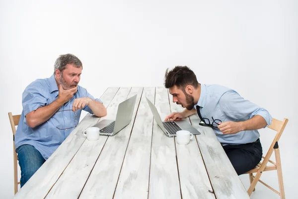 Die beiden Kollegen, die zusammen im Büro auf weißem Hintergrund arbeiten — Stockfoto