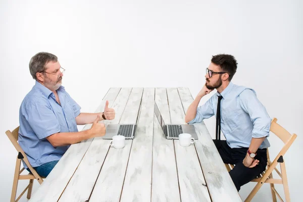 Die beiden Kollegen, die zusammen im Büro auf weißem Hintergrund arbeiten — Stockfoto