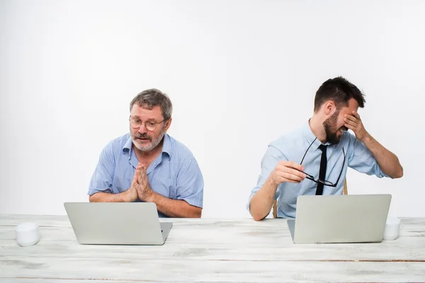 Les deux collègues travaillent ensemble au bureau sur fond blanc — Photo