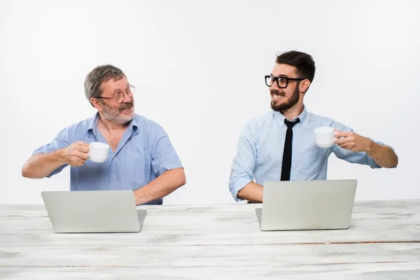 Die beiden Kollegen, die zusammen im Büro auf weißem Hintergrund arbeiten — Stockfoto