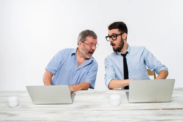 The two colleagues working together at office on white background